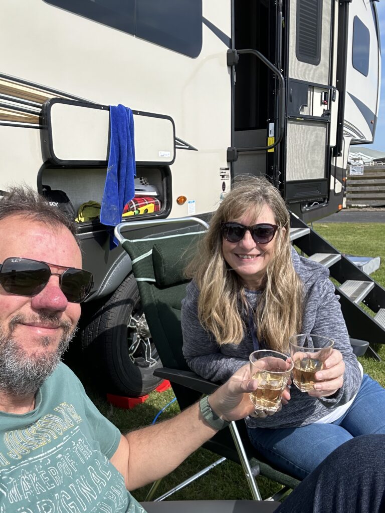 A couple camping holding a drink