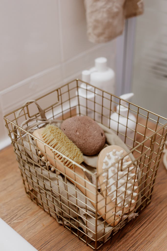 Elegant wire basket with natural bath brushes and pumice stone in a cozy bathroom setting.