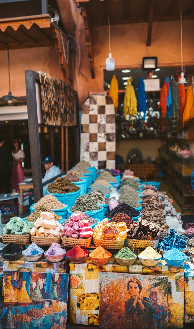 Colorful spices and fabrics displayed at an outdoor market in Marrakesh, Morocco.