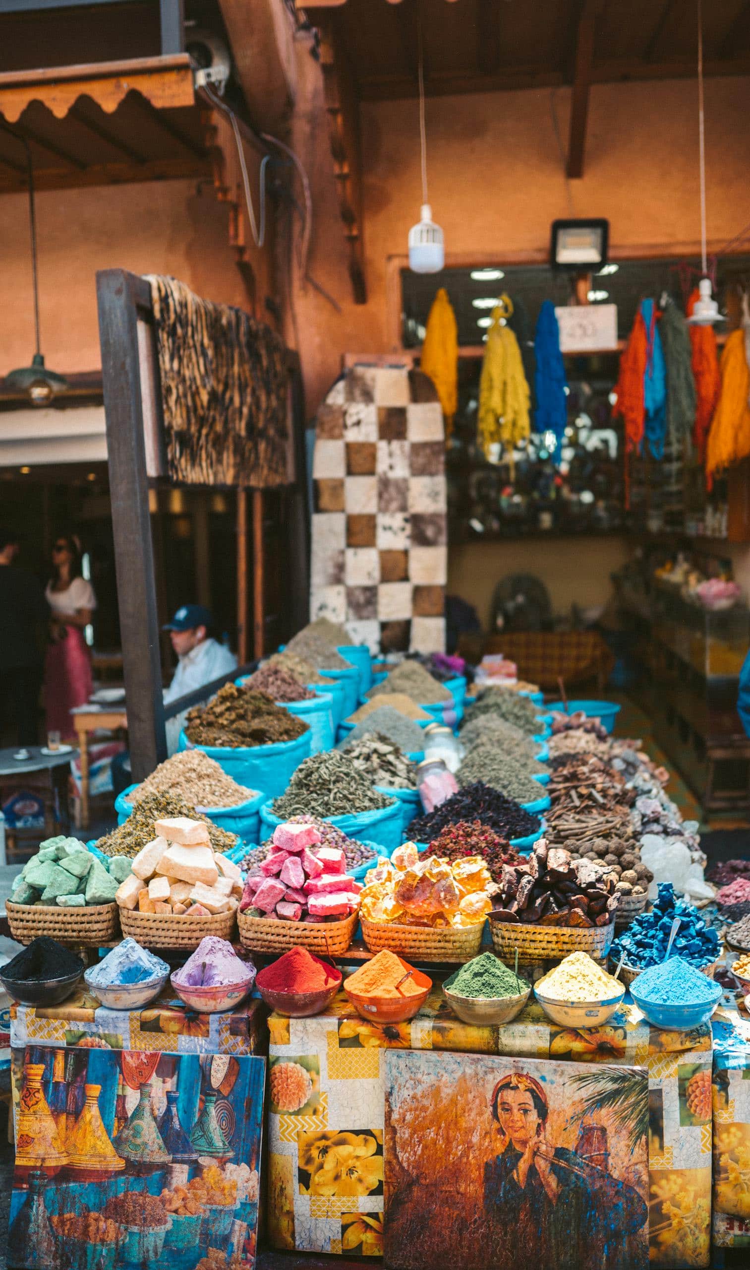 Colorful spices and fabrics displayed at an outdoor market in Marrakesh, Morocco.